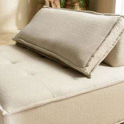 Fauteuil chauffeuse tissu capitonné beige avec coussin